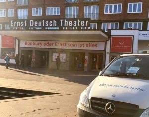 Haupteingang des Ernst Deuitsch Theaters, ein Wagen des NDR im Vordergrund. Gäste gehen zum Eingang